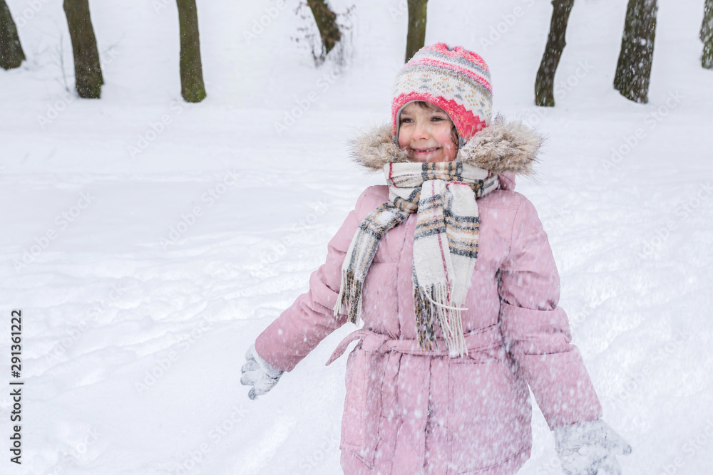 Little girl playing in the park on a winter day. Winter holidays, active lifestyle. Little girl playing in the park on a winter day. Winter holidays, active lifestyle.