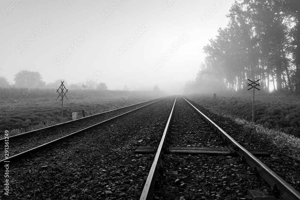 Railroad tracks in the fog. Foggy morning over a railway line in Central Europe.
