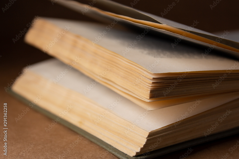 Old book on brown background in the dark close up Old book on brown background in the dark close up