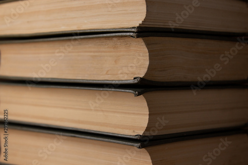 Several old books lie horizontally close-up.