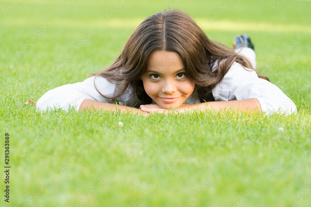 Kid relaxing outdoors. School break for rest. Adorable pupil. Girl kid laying green grass. Girl school uniform enjoy relax. Take care of yourself. Little schoolgirl. Relax at school yard. Nice time Kid relaxing outdoors. School break for rest. Adorable pupil. Girl kid laying green grass. Girl school uniform enjoy relax. Take care of yourself. Little schoolgirl. Relax at school yard. Nice time