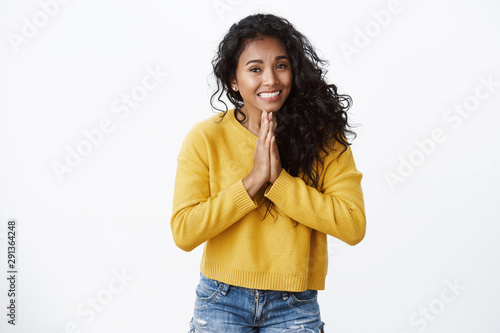 Pretty please help me out asap. Cute african american girl in yellow sweater hold hands in pray, smiling with clingy look, begging for favour, asking lend car, apologizing for being late