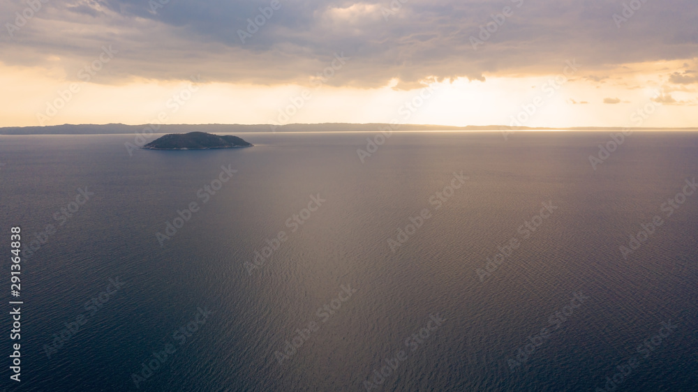 Aerial sunset view of amazing Neos Marmaras cityscape and distant turtle island in Greece.