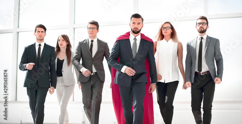 businessman in a red superhero cloak and his business team photo