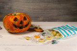 Halloween pumpkin and candies on a white table