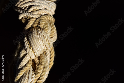 Cuadro en lienzo Closeup of a complicated, undetachable knot of hemp rope against a dark backgrou