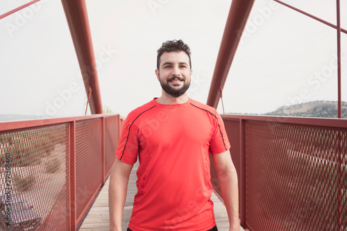 Obraz na plátně Sports mid adult man warming on a bridge after running