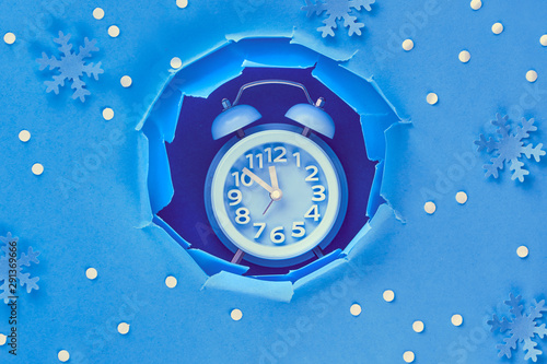 Happy New Year 2020! Aarm clock in paper hole, flat lay on blue paper photo