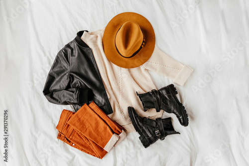 Принти на полотні Leather jacket and white warm sweater with brown trousers and hat on white sheet