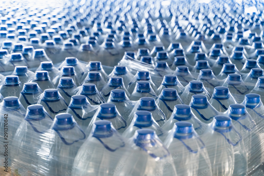 Many plastic bottles with drinking pure water and blue caps Many plastic bottles with drinking pure water and blue caps