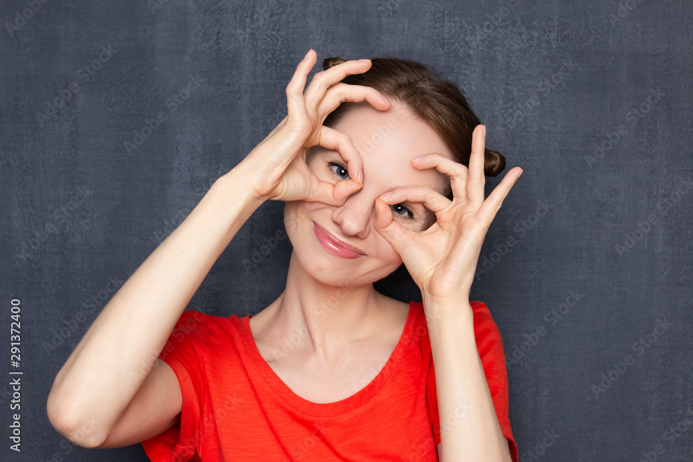 Portrait of happy cute girl making ok gestures like binoculars Portrait of happy cute girl making ok gestures like binoculars