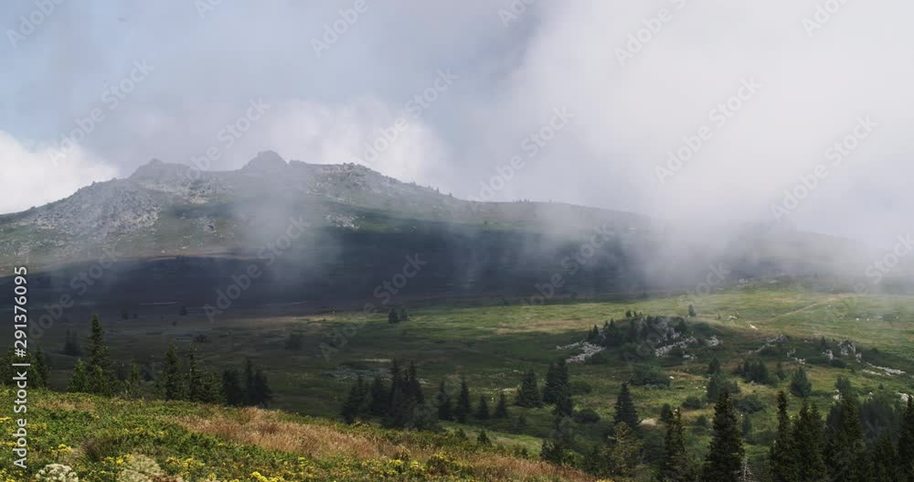 Clouds rolling over a valley in front of the Ushite mountaintop in Vitosha mountain, Bulgaria on a summer day. Clouds rolling over a valley in front of the Ushite mountaintop in Vitosha mountain, Bulgaria on a summer day.