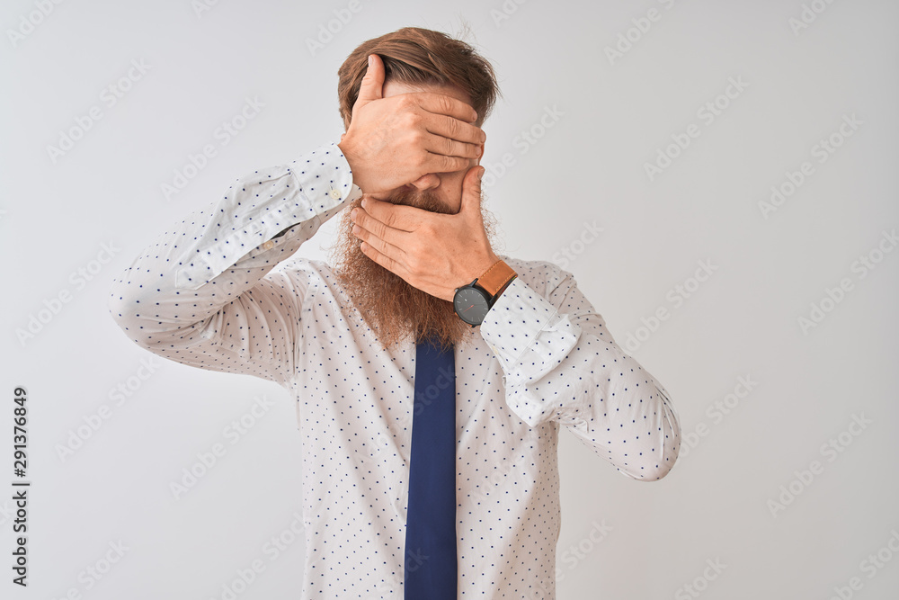 Young redhead irish businessman standing over isolated white background Covering eyes and mouth with hands, surprised and shocked. Hiding emotion Young redhead irish businessman standing over isolated white background Covering eyes and mouth with hands, surprised and shocked. Hiding emotion