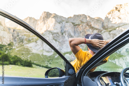 Fotografie Man Laid Down on the Car Bonnet While Enjoy the Views of Nature.