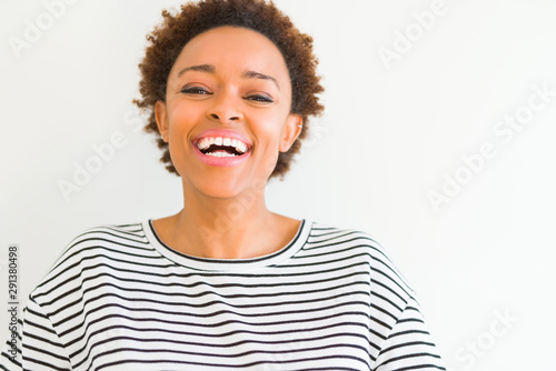 Beautiful young african american woman smiling confident to the camera showing teeth over isolated white background