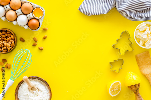 Kitchen frame. Dough ingredients and crockery on yellow background top view copy space