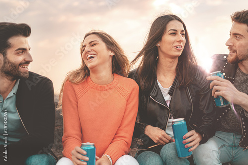 Billede på lærred Young friends group drinking together canned beers outdoors at sunset