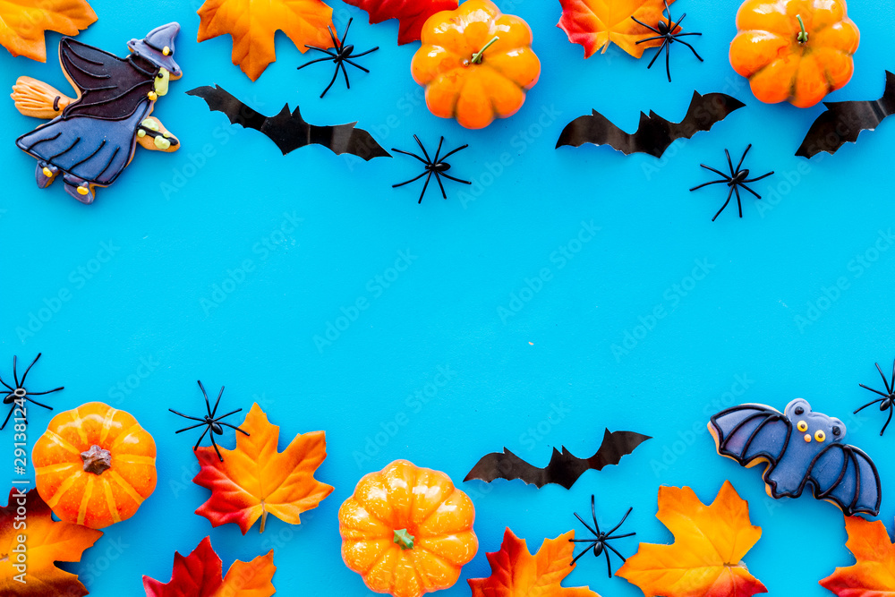 Halloween frame with pumpkins, spiders and bats on blue background top view copy space