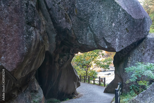 Ishimon, a natural granite arched stone door at Mitake Shosenkyo Gorge. A popular tourist attractions. Autumn foliage scenery view in sunny day. Kofu, Yamanashi Prefecture, Japan photo