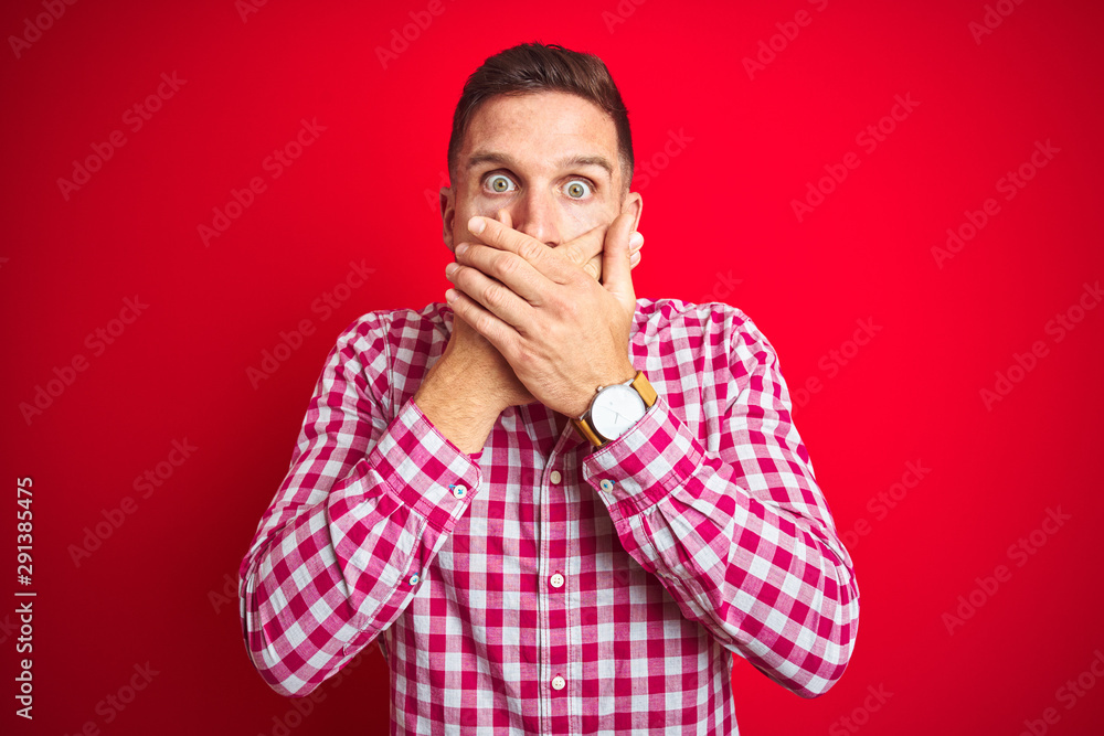 Young handsome man over red isolated background shocked covering mouth with hands for mistake. Secret concept. Young handsome man over red isolated background shocked covering mouth with hands for mistake. Secret concept.