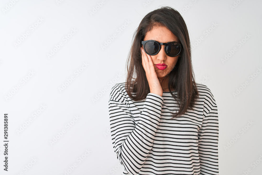 Chinese woman wearing striped t-shirt and sunglasses standing over isolated white background thinking looking tired and bored with depression problems with crossed arms. Chinese woman wearing striped t-shirt and sunglasses standing over isolated white background thinking looking tired and bored with depression problems with crossed arms.
