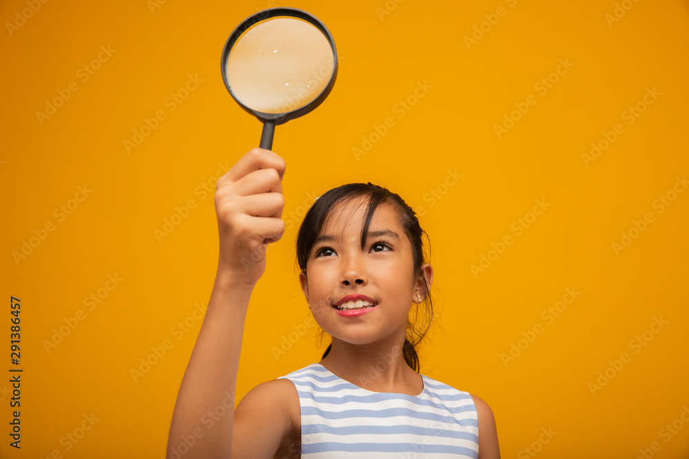 Portrait of happy little Asian child with magnifying glass. Portrait of happy little Asian child with magnifying glass.
