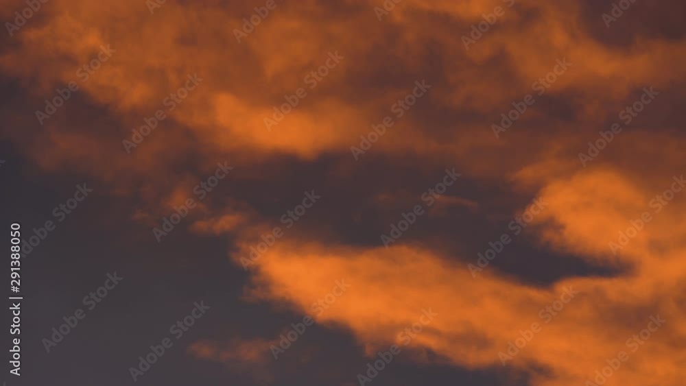 Yellow-orange clouds glowing by disappearing rays at sunset floating across dramatic dark purple and violet thunderclouds in sky to change weather. Summer amazing view natural meteorology background. Yellow-orange clouds glowing by disappearing rays at sunset floating across dramatic dark purple and violet thunderclouds in sky to change weather. Summer amazing view natural meteorology background.