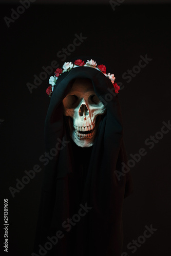 Death wearing a crown of flowers and a black robe