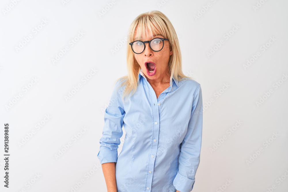 Middle age businesswoman wearing elegant shirt and glasses over isolated white background afraid and shocked with surprise and amazed expression, fear and excited face.
