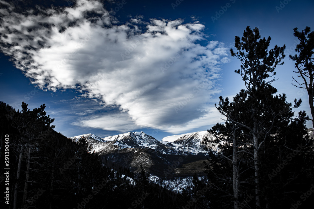 Dynamic Clouds Over Snow-Capped Rocky Mountains