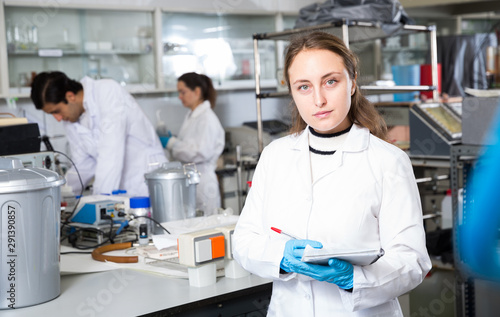Female chemist writing results of experiments