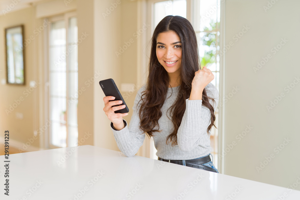 Young woman using smartphone sending a message screaming proud and celebrating victory and success very excited, cheering emotion Young woman using smartphone sending a message screaming proud and celebrating victory and success very excited, cheering emotion