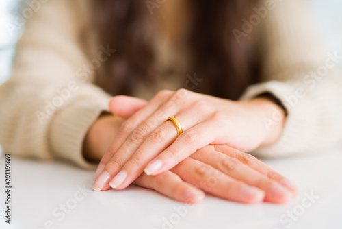 Close up of woman hands on each other wearing a golden alliance for marriage