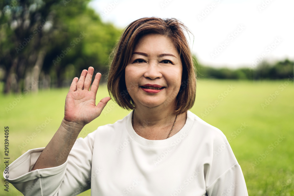 Portrait of happy senior adult elderly asia women smiling at camera waving and saying hello to you Portrait of happy senior adult elderly asia women smiling at camera waving and saying hello to you