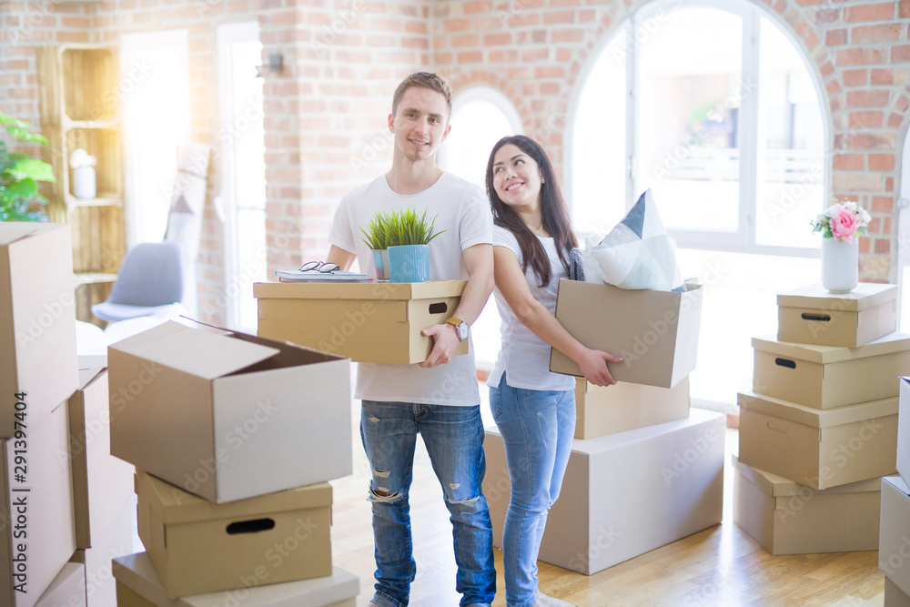Young beautiful couple moving cardboard boxes at new home Young beautiful couple moving cardboard boxes at new home