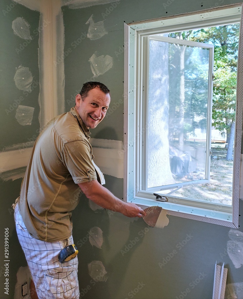Smiling carpenter spackle window wall 