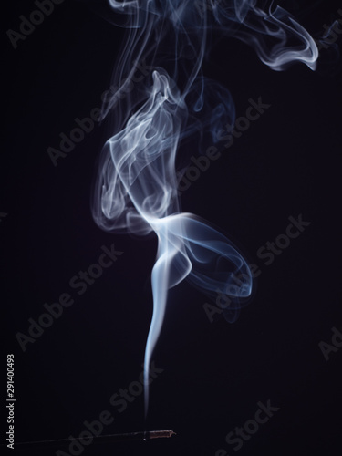 Abstract cloud of white smoke swirling on black background, close up view, isolated. Structure of white smoke, brush effect. Burning incense for meditation and relaxation, abstract background photo