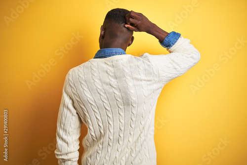 Quadro em tela African american man wearing denim shirt and white sweater over isolated yellow
