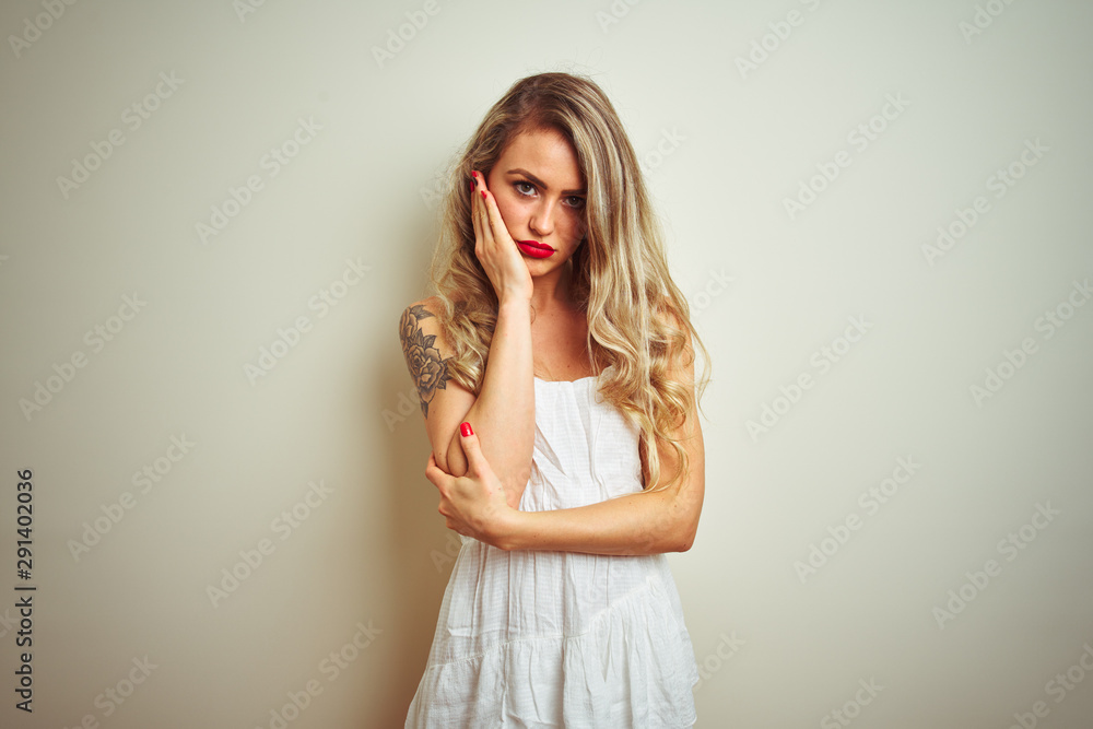 Young beautiful woman wearing casual dress standing over white isolated background thinking looking tired and bored with depression problems with crossed arms. Young beautiful woman wearing casual dress standing over white isolated background thinking looking tired and bored with depression problems with crossed arms.