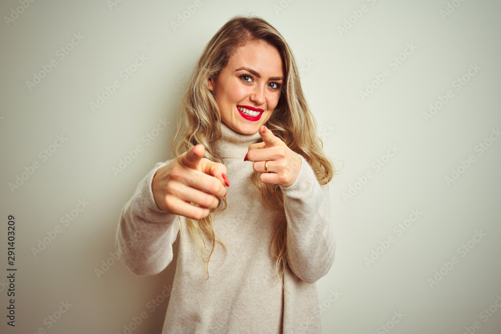 Beautiful woman wearing winter turtleneck sweater over isolated white background pointing fingers to camera with happy and funny face. Good energy and vibes. Beautiful woman wearing winter turtleneck sweater over isolated white background pointing fingers to camera with happy and funny face. Good energy and vibes.