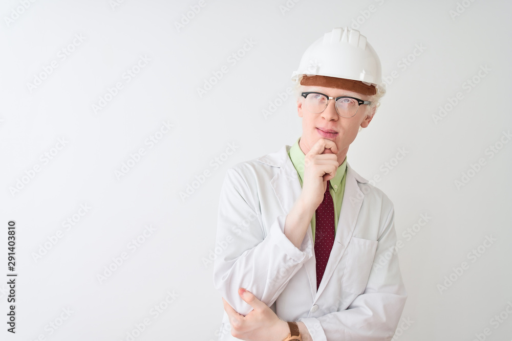 Albino scientist man wearing glasses and helmet standing over isolated white background with hand on chin thinking about question, pensive expression. Smiling with thoughtful face. Doubt concept.