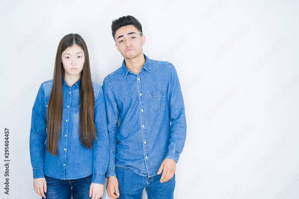 Beautiful young asian couple over white isolated background depressed and worry for distress, crying angry and afraid. Sad expression. Beautiful young asian couple over white isolated background depressed and worry for distress, crying angry and afraid. Sad expression.