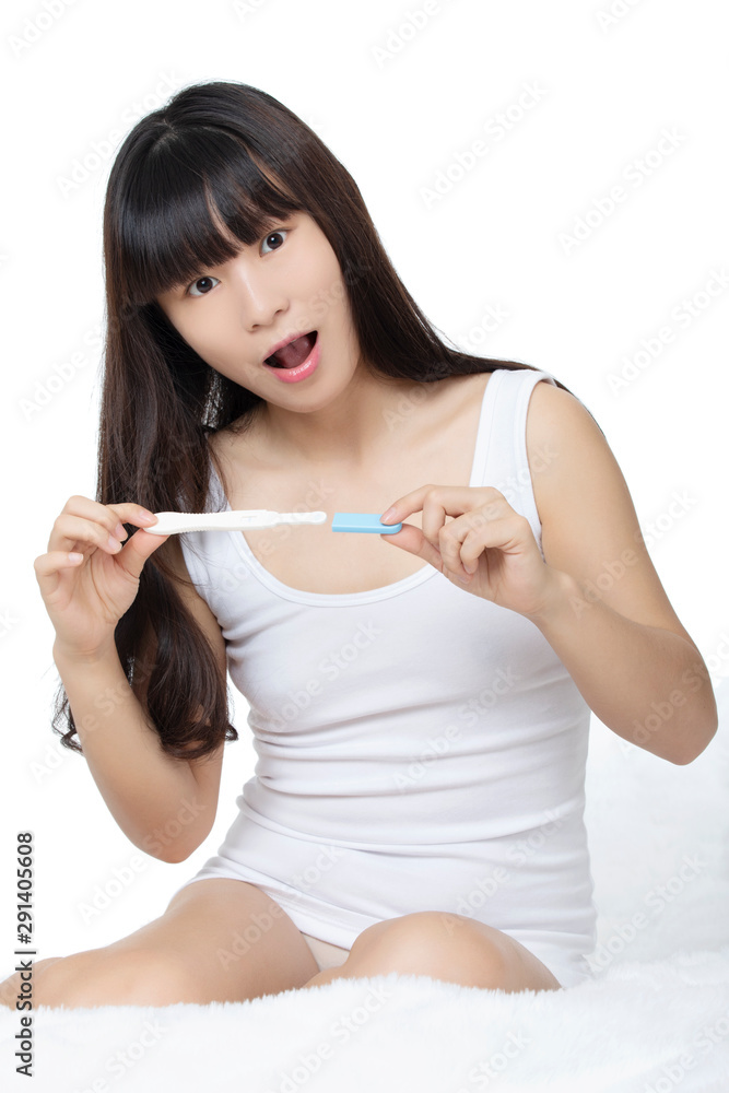 Asian woman holding early pregnancy tester isolated on white background Asian woman holding early pregnancy tester isolated on white background