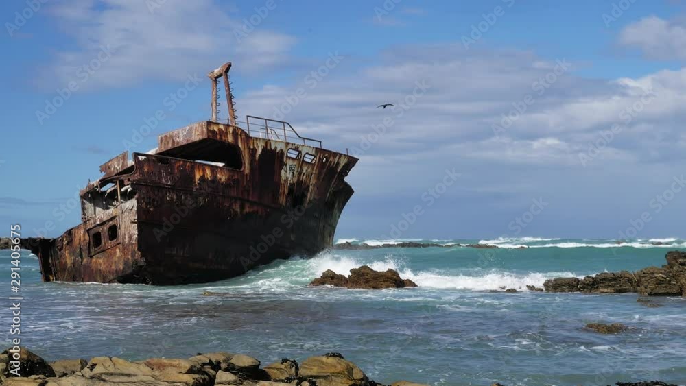 Old weathered shipreck in shallows with waves running in, rocky coastline of L'Agulhas, South Africa, close-up static shot Old weathered shipreck in shallows with waves running in, rocky coastline of L'Agulhas, South Africa, close-up static shot