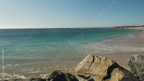 Small wave pushing high up onto beautiful deserted beach, panning shot photo