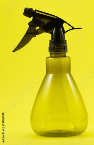 spray bottle of water isolated on yellow background