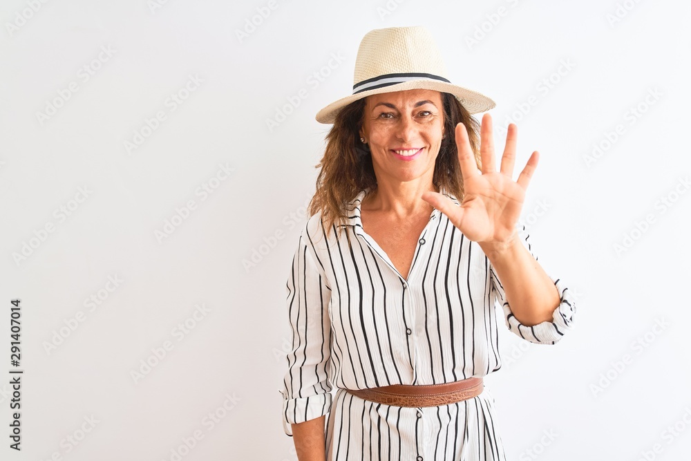 Middle age businesswoman wearing striped dress and hat over isolated white background showing and pointing up with fingers number five while smiling confident and happy. Middle age businesswoman wearing striped dress and hat over isolated white background showing and pointing up with fingers number five while smiling confident and happy.