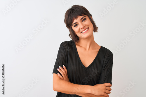 Young beautiful woman wearing black t-shirt standing over isolated white background happy face smiling with crossed arms looking at the camera. Positive person.