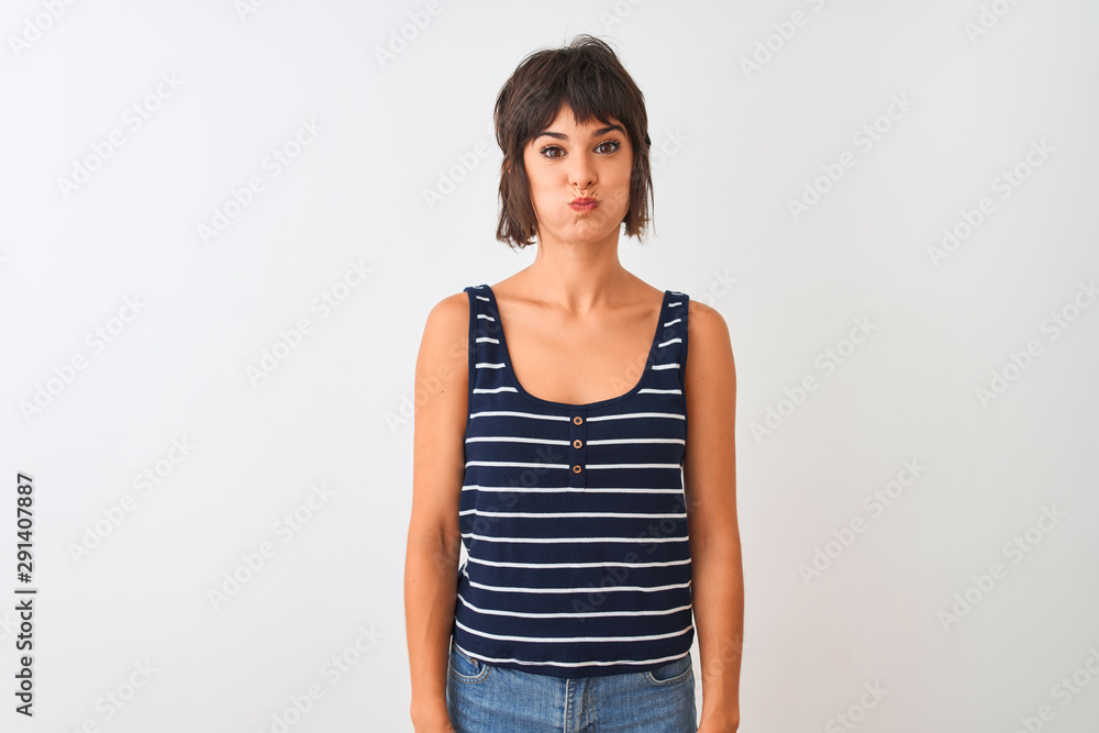 Young beautiful woman wearing striped t-shirt standing over isolated white background puffing cheeks with funny face. Mouth inflated with air, crazy expression. Young beautiful woman wearing striped t-shirt standing over isolated white background puffing cheeks with funny face. Mouth inflated with air, crazy expression.