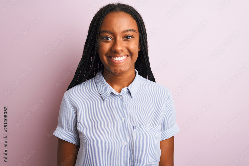Young african american woman wearing striped shirt standing over isolated pink background with a happy and cool smile on face. Lucky person. Young african american woman wearing striped shirt standing over isolated pink background with a happy and cool smile on face. Lucky person.